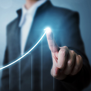 Business man predicting future outcomes by drawing an increasing line on bar graphs.