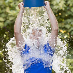 A person throwing a bucket of water over their heads in support of the ALS challenge.