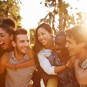 Bunch of Millennials are having fun playing games where the men have to run with girls on their back.